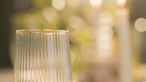 Close-Up-Of-Gold-Rimmed-Glass-On-Table-Set-For-Meal-At-Wedding-Reception